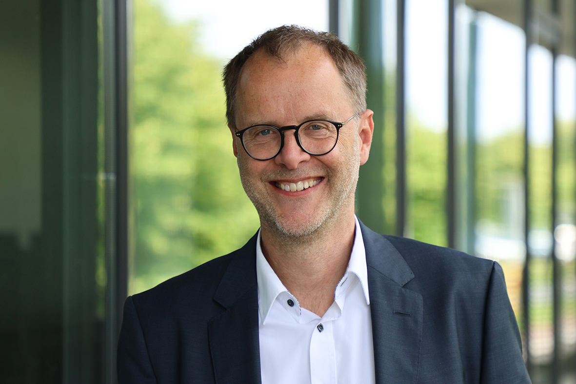 Prof. Dr. Bernd Kriegesmann. Foto: WH/Britta Stock Das Bild zeigt Herrn Prof. Dr. Bernd Kriegesmann im Porträt. Er lächelt und trägt ein dunkelblaues Sakko über einem weißen Hemd. Der Bildhintergrund ist unscharf.