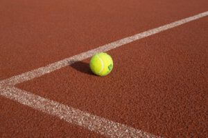 Ein Tennisball liegt auf dem Tennisfeld.