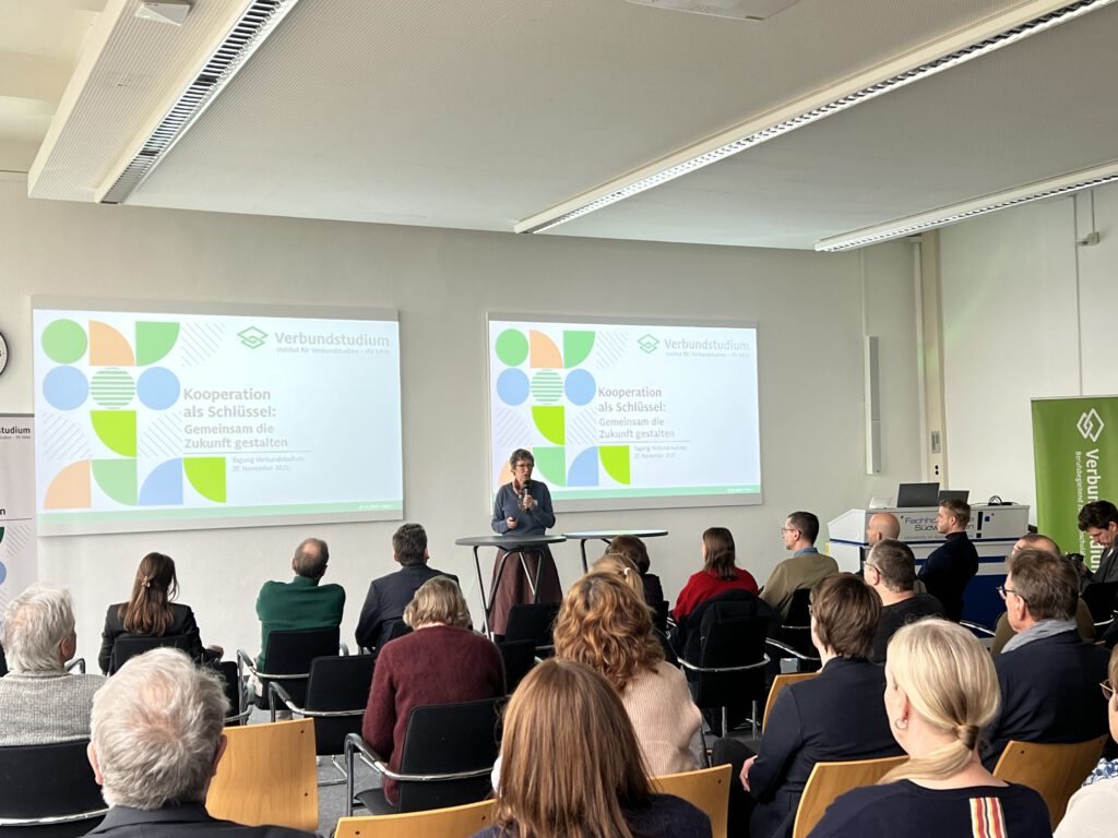 Auf dem Bild sieht man Frau Prof. Dr. Susanne Staude während sie auf einer Tagung in Hagen eine Rede hält. Im Vordergrund des Bildes ist das Publikum zu sehen. Foto: HochschulenNRW/Krüger
